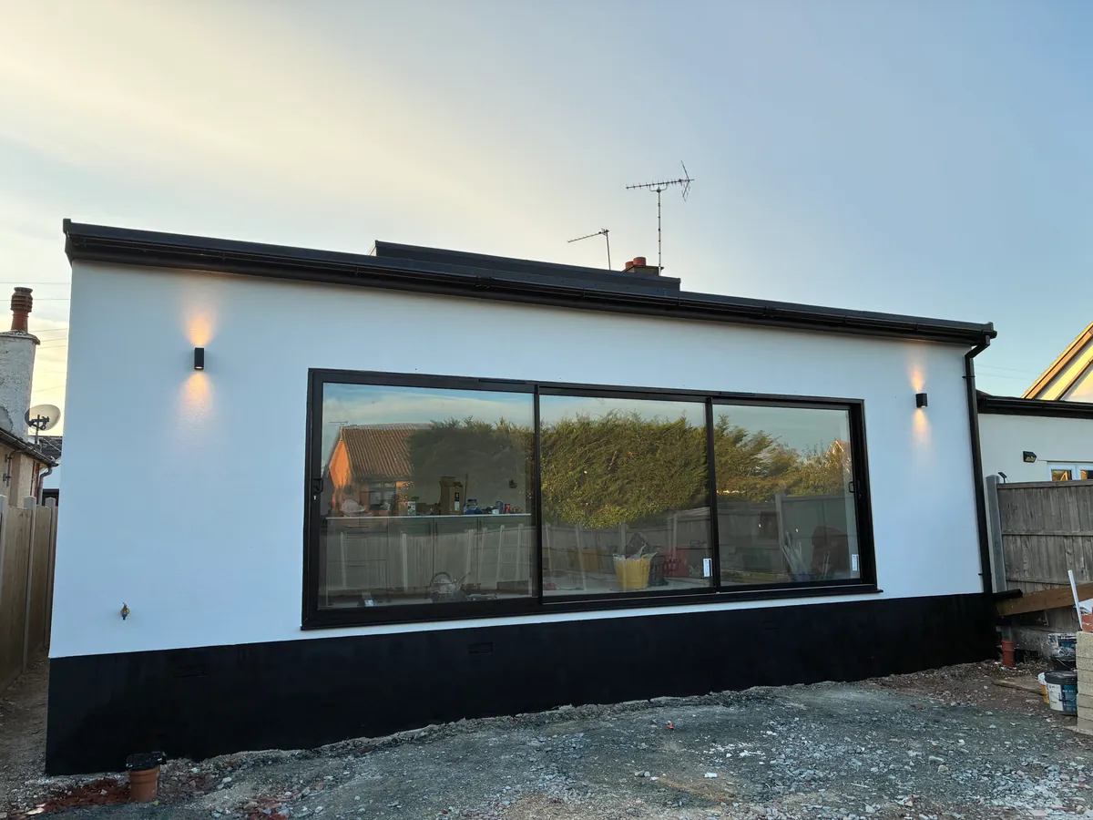 White-rendered rear extension with wide black-framed glazing